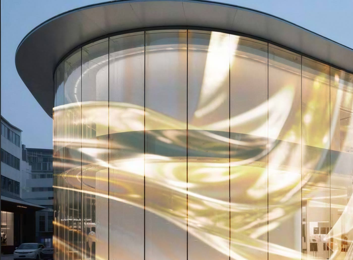 Kurvet glasfacade med transparent LED-film der viser levende indhold
